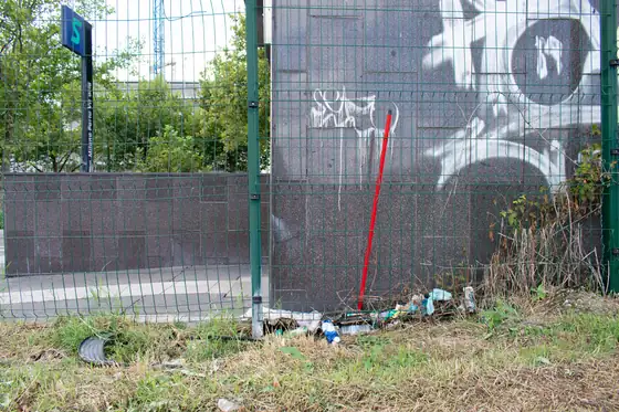 Graffiti on a wall beside a blue sign