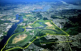 Aerial view of a river landscape traced by a yellow-green line of a proposed park